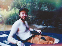 a man sitting in a canoe with tattoos
