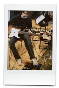 a man playing a guitar in a recording studio