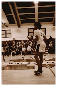 a girl is playing basketball in a gym