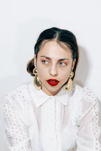 a woman wearing a white shirt and red lipstick