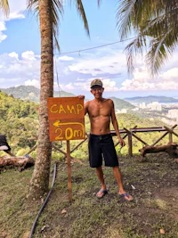 a man standing in front of a sign that reads camp zoo