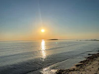 the sun is setting over a body of water