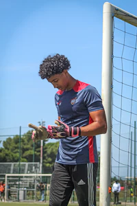 a soccer player is standing next to a goal