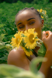 a woman holding sunflowers in a field