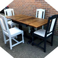 a dining table and chairs with a brick wall behind them