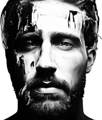 a black and white portrait of a man with paint on his face