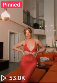 a woman in a red dress is posing in a living room