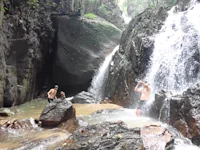 a group of people standing in front of a waterfall
