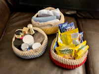 three crocheted baskets on a couch