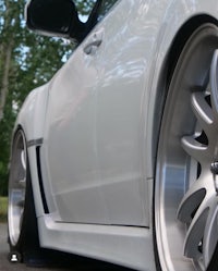 a close up of a white car with rims and wheels