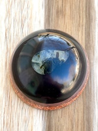 a black stone on top of a wooden table