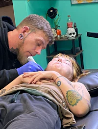 a man tattooing a woman in a tattoo shop