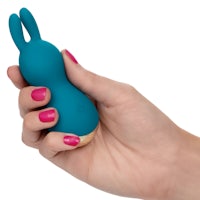 a hand holding a blue bunny toy