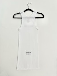 a white tank top hanging on a hanger