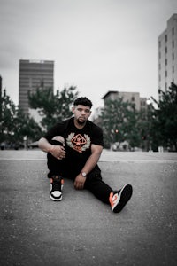 a man sitting on the ground in a city