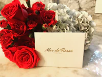 a bouquet of red and white roses with a card