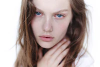 a young woman with blue eyes posing for a photo