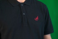 a man wearing a black polo shirt with a red logo