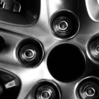 a black and white photo of a car wheel