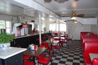 the inside of a diner with red booths and checkered floors