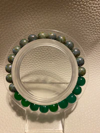 a bracelet with green and blue beads on it