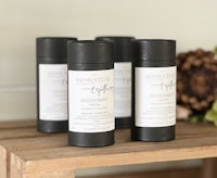 four bottles of deodorant sitting on a wooden table