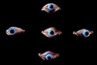 a set of five copper rings with blue eyes
