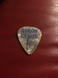 a guitar pick with the name aaron lewis on it