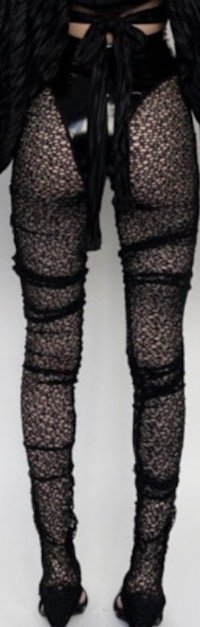 the back of a woman wearing black lace leggings