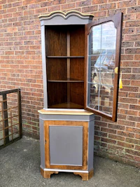 a corner cabinet with a door on it