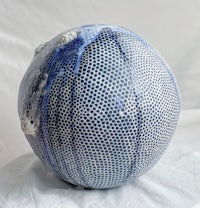 a blue and white ceramic ball on a white surface