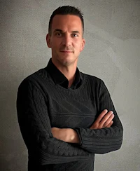 a man in a black sweater posing for a photo