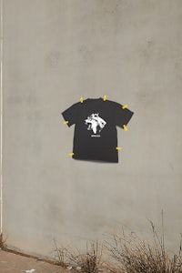 a black t - shirt is hanging on a wall