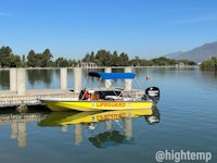 a yellow boat docked at a dock in a lake
