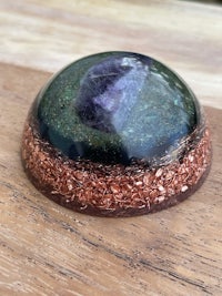 an amethyst sphere on a wooden table