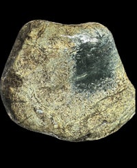 a rock with a green color and a black background