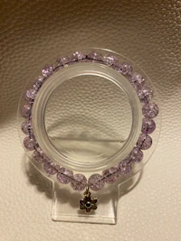 a clear glass mirror with purple beads on it