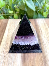 an amethyst pyramid on top of a wooden table