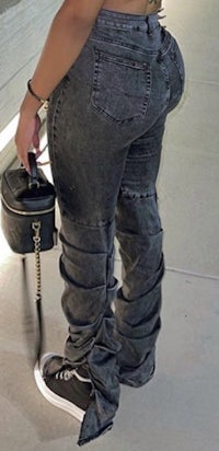 a woman wearing black jeans and a black purse