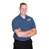 a man in a blue shirt with his arms crossed