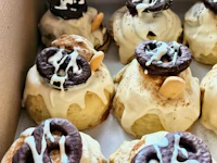 a box of pretzel doughnuts with icing and sprinkles