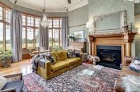 a living room with large windows and a fireplace