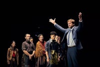a man in a suit standing in front of a group of people