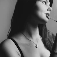a black and white photo of a woman drinking wine