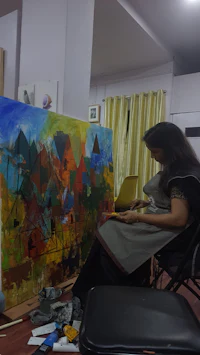 a woman working on a painting in a studio