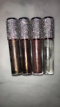four bottles of liquid eyeshadow with rhinestones on them