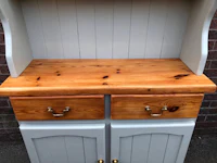 a white hutch with two drawers and a wooden top