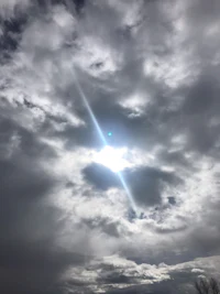 the sun shines through a cloudy sky