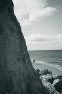 a black and white photo of a person on a beach