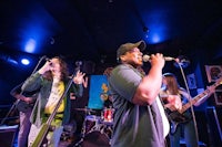 a group of people singing on stage at a concert